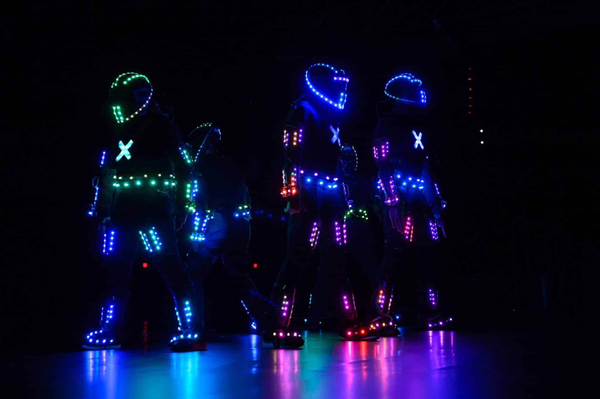 Glowing suits on stage at a corporate event