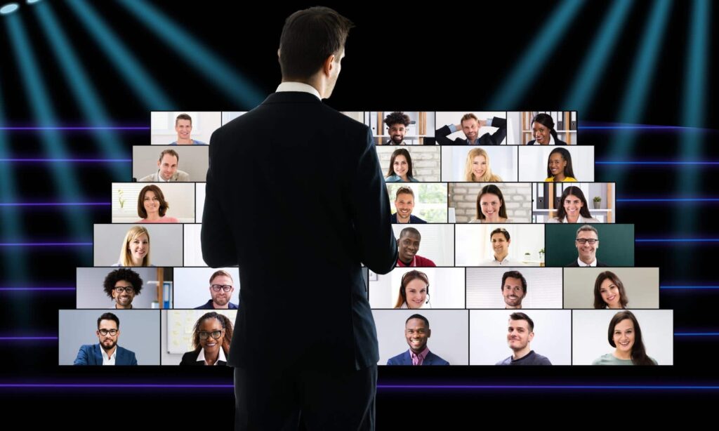 Keynote speaker looking at audience on screens during virtual event