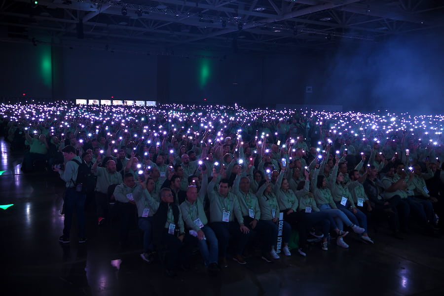 conference attendees holding up their phones to create collective experience