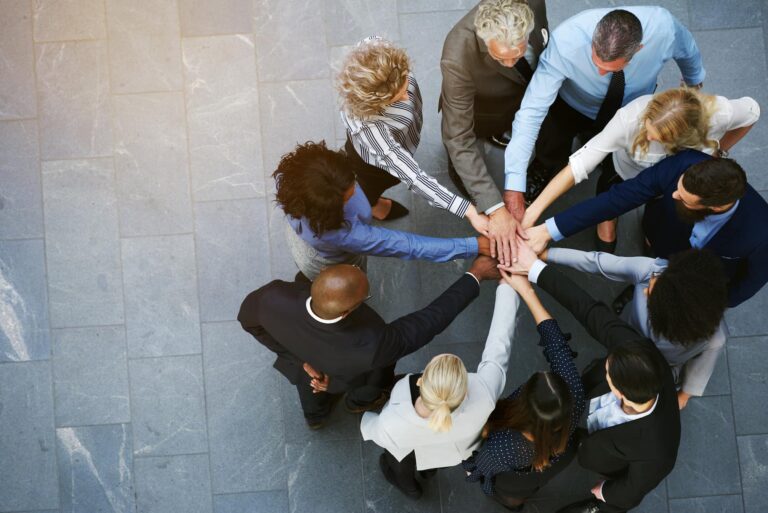corporate employees placing their hands in a circle